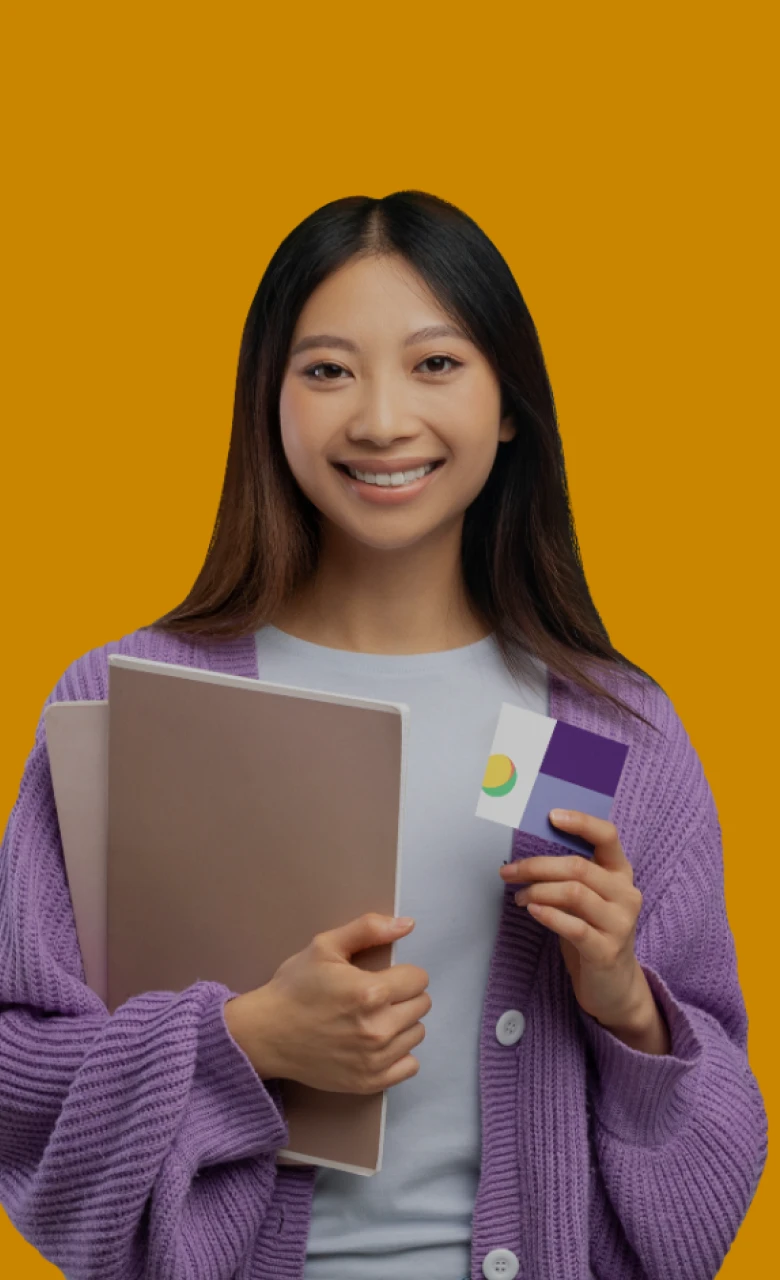 Student holding notebooks and a passport